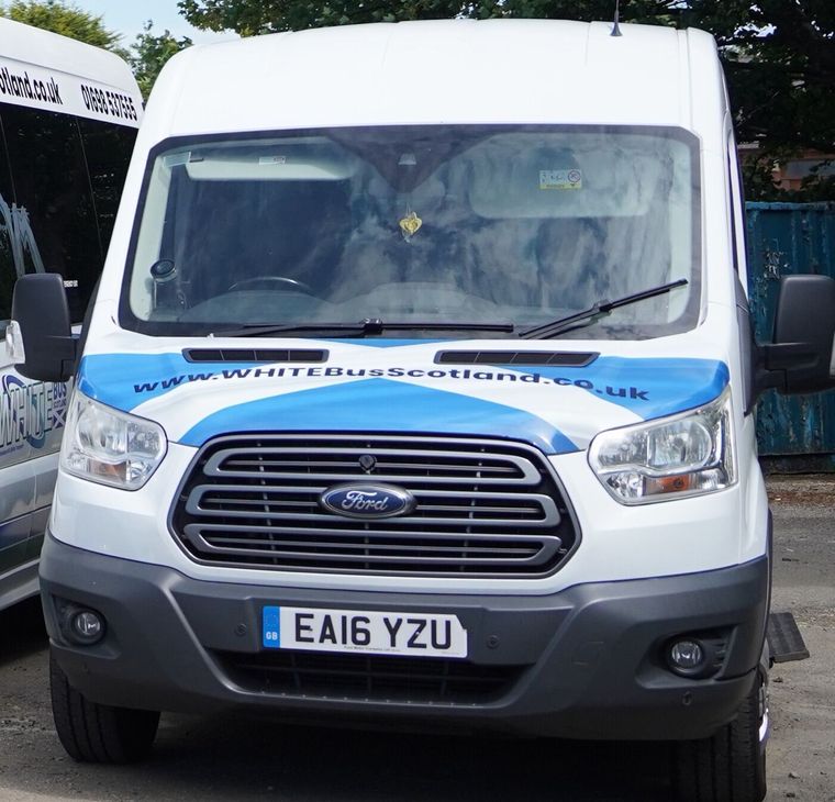 The front of the Ford Transit minibus in the blue and white livery